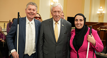 John Pare, Representative Steny Hoyer, and Ronza Othman pose for a photograph.